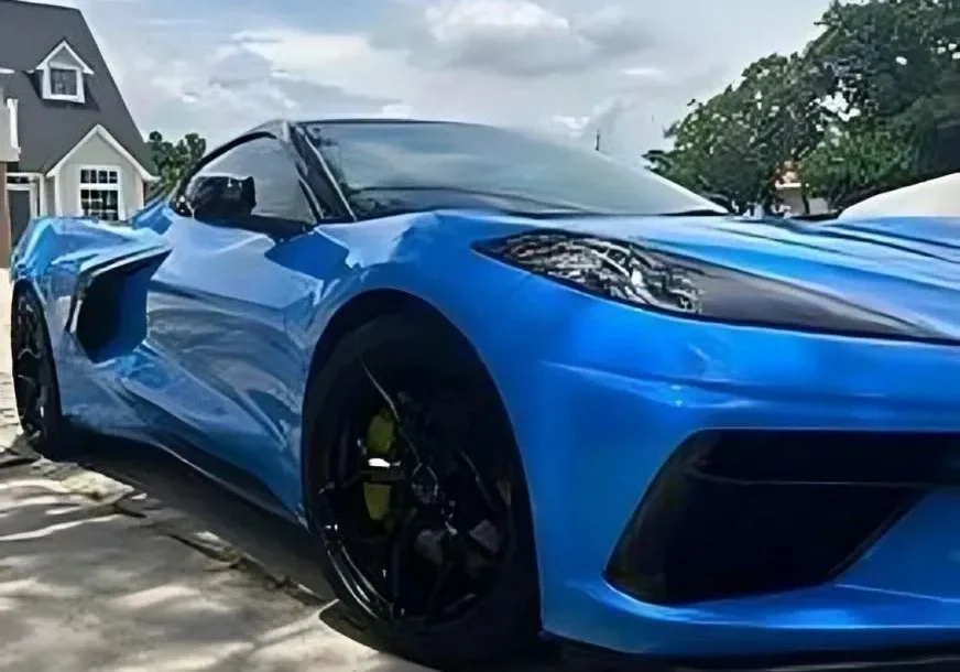 Sleek blue sports car parked outdoors on a sunny day.